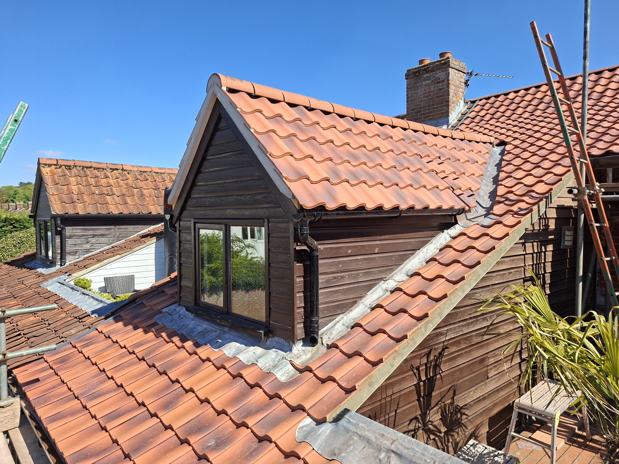 A new clay pantile roof around a timber-clad dormer
